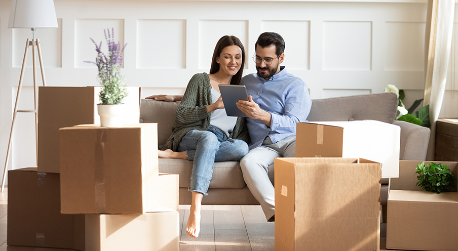 man and woman sitting on couch with ipad