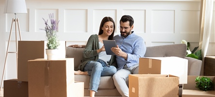 man and woman sitting on couch with ipad