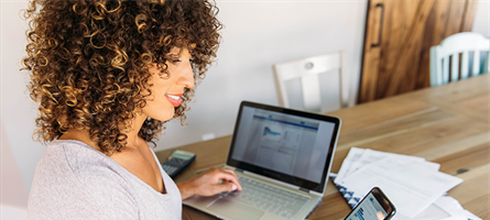 Woman checking phone and computer