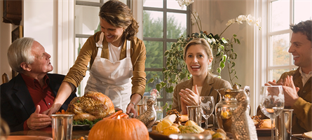 Family sitting around a table with pumpkins and food