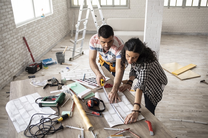 Couple measuring wallpaper for home renovation project