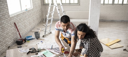 Couple measuring wallpaper for home renovation project