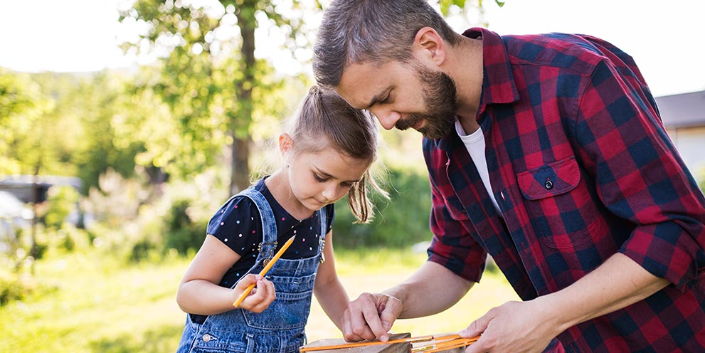 Father and daughter building a birdhouse together