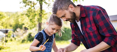 Father and daughter building a birdhouse together