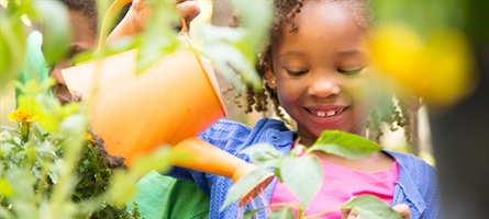 Little girl watering flowers and gardening