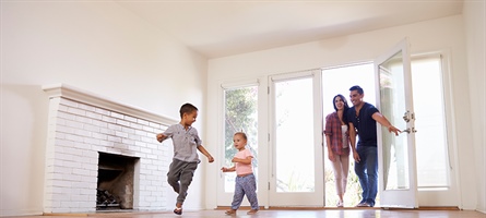 man, woman, and two children walk through the door of an empty room