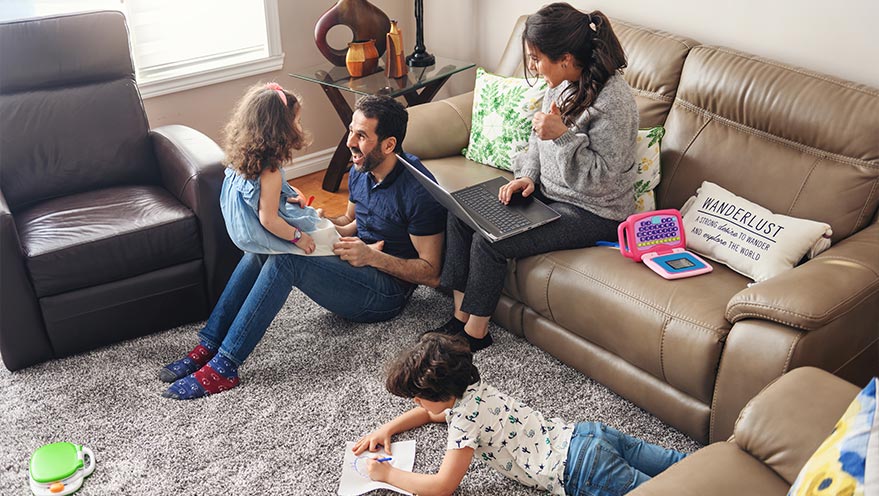 Mother, father, son and daughter crowd around couch
