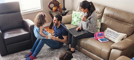 Mother, father, son and daughter crowd around couch