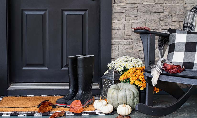 door/entrance decorated with fall decor, leaves, pumpkins and flannel