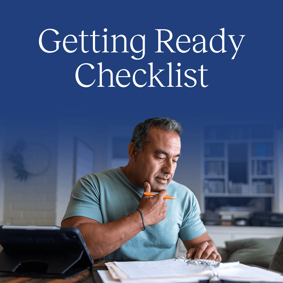 A middle-aged man sits at a desk reviewing a checklist